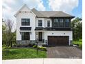 Two-story white house with a dark gray roof, stone accents, and a two-car garage at Lot 113 Mayes Meadow Dr # Covington, Cornelius, NC 28078