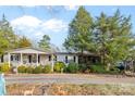 Inviting single-story house showcasing a covered front porch, well-maintained landscaping, and a gravel driveway at 1517 Cuthbertson Rd, Waxhaw, NC 28173