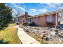 Brick home with a walkway, landscaping, and a Japanese lantern at 2718 Moores Park Dr, Charlotte, NC 28214