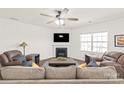 Comfortable living room with neutral tones, a ceiling fan, fireplace, and hardwood floors at 7324 Teague Dr, Gastonia, NC 28056