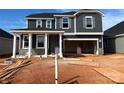 New two-story home featuring dark siding, white trim, and an attached two car garage at 1016 Farm Branch Ct, Indian Trail, NC 28079