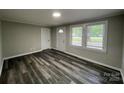 Bright living room with modern gray wood flooring, freshly painted walls, and plenty of natural light at 1404 Linwood Rd, Gastonia, NC 28052