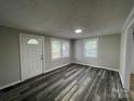 Bright living room with modern gray wood flooring, freshly painted walls, and plenty of natural light at 1404 Linwood Rd, Gastonia, NC 28052