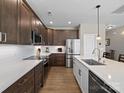 Modern kitchen featuring stainless steel appliances, wooden cabinets, and a spacious center island at 14106 Magnolia Walk Dr, Huntersville, NC 28078