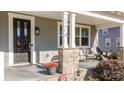 Front porch with stone pillars, chairs, and potted plants at 174 Country Lake Dr, Mooresville, NC 28115