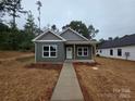A cozy home with modern siding, white-framed windows, and a inviting front porch at 211 Benfield Rd, Kings Mountain, NC 28086