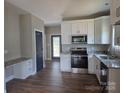Modern kitchen featuring stainless steel appliances, granite counters, ample cabinet space, and beautiful hardwood floors at 211 Benfield Rd, Kings Mountain, NC 28086