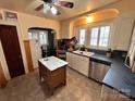 Well-lit kitchen featuring white cabinets, stainless steel appliances, and tile flooring at 225 Wilson St, Albemarle, NC 28001