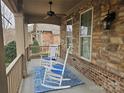 Inviting front porch with rocking chairs and a blue rug at 240 Harrison Ln, Locust, NC 28097