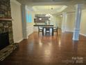 Spacious living room with hardwood floors, stone fireplace, and high ceilings at 240 Harrison Ln, Locust, NC 28097