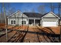 New construction home with gray siding, stone accents and a two-car garage at 3015 Buffet Ln, Monroe, NC 28110