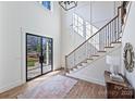 Open foyer with a staircase, hardwood floors, large front door, and natural light pouring in at 3319 Gresham Pl, Charlotte, NC 28211