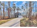 Two-story house nestled in a wooded area with a long driveway at 5510 Brickstone Dr, Charlotte, NC 28227