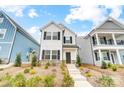 Two-story white house with black shutters, stone accents, and landscaping at 693 Candela Ct, York, SC 29745