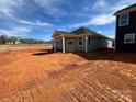 Backyard view of new construction featuring a covered patio and backyard awaiting your personal touch and landscaping at 1012 Farm Branch Ct, Indian Trail, NC 28079