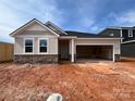 Charming single-story home with stone accents, a two-car garage, and a covered front porch at 1020 Farm Branch Ct, Indian Trail, NC 28079