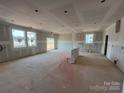 Spacious unfinished living room featuring bright windows and a sliding glass door to the backyard at 1020 Farm Branch Ct, Indian Trail, NC 28079