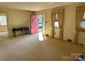 Living room with red door, carpet, and large windows at 147 W Mcneely Ave, Mooresville, NC 28115