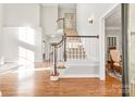 Bright foyer with hardwood floors, staircase with decorative handrail, and views into living spaces at 15613 Glen Miro Dr, Huntersville, NC 28078