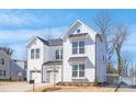 Bright, modern white home with a two-car garage, showcasing clean lines and inviting curb appeal at 1739 Dunloe St # 8242, Charlotte, NC 28206