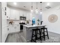 Open concept kitchen with white cabinets, an island, and gray flooring at 1739 Dunloe St # 8242, Charlotte, NC 28206