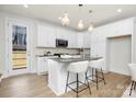 Modern kitchen featuring an island, stainless steel appliances, white cabinets and stylish pendant lighting at 1739 Dunloe St # 8242, Charlotte, NC 28206