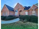 Brick home with landscaped yard and walkway at 210 Classic Ct, Mount Holly, NC 28120