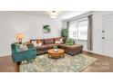 Inviting living room featuring a brown sofa, an area rug, and natural lighting at 4321 Gillespie Ct, Charlotte, NC 28205