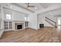 Bright living room with fireplace, built-in shelving, hardwood floors, and elegant beamed ceilings at 718 Barrel Aly, Fort Mill, SC 29715