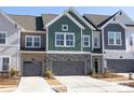 Attractive townhomes feature varied siding, stone accents, and attached garages at 8125 Houser St, Cornelius, NC 28031