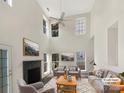 Virtually staged living room with gray sofas, a fireplace, and high ceilings at 8200 Suttonview Dr, Charlotte, NC 28269