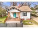 Charming single-story home featuring a wooden porch, a bright blue door, and a red brick chimney at 8228 Moores Chapel Rd, Charlotte, NC 28214