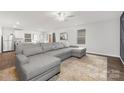 Spacious living room with gray sectional sofa and wood-look floors at 9025 Creedmore Hills Dr, Charlotte, NC 28214