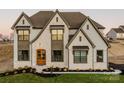 Two-story house with stone and beige siding, a two-car garage, and landscaping at Lot 1 Mayes Meadow Dr # Devonshire, Cornelius, NC 28078