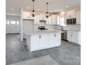 White kitchen with large island, stainless steel appliances, and gray tile floors at Lot 113 Mayes Meadow Dr # Savanh, Cornelius, NC 28078