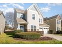 Two-story home featuring neutral siding, a three-car garage, manicured landscaping, and a well-maintained lawn at 10149 Elizabeth Crest Ln, Charlotte, NC 28277