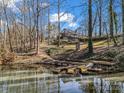 Scenic view of a lakeside property with a wooden dock, surrounded by lush greenery at 108 Three Oaks Ln, Kings Mountain, NC 28086