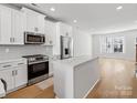 Modern kitchen featuring white cabinets, stainless steel appliances, and quartz countertops at 1122 Pegram Crossing Dr, Charlotte, NC 28205