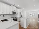 Modern kitchen with white cabinets, quartz countertops, and stainless steel appliances at 1122 Pegram Crossing Dr, Charlotte, NC 28205