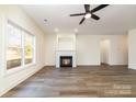 Spacious living room with wood-look floors, fireplace, and large window with outdoor views at 1135 Rudder Cir, Salisbury, NC 28146