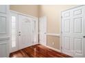 Bright foyer features a front door with sidelights, hardwood floors, and neutral wall paint at 122 Ardmore Pl, Mooresville, NC 28117