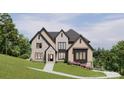 Two-story house with stone and brick accents, a large front yard, and a walkway leading to the entrance at 1312A Reflection Pointe Blvd # 331, Belmont, NC 28012