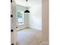 Sunny bedroom showcasing light wood floors, white walls, ample natural light, and black door hardware at 1912 St John St, Charlotte, NC 28216