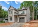 Stylish two-story home with gray siding, a modern roofline, and an attached gray garage at 1912 St John St, Charlotte, NC 28216
