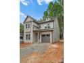 Attractive gray two-story home with an attached garage and modern design elements in a lush setting at 1912 St John St, Charlotte, NC 28216
