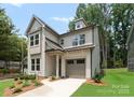 Two-story home with neutral siding features manicured lawn, one car garage, and craftsman details at 1912 St John St, Charlotte, NC 28216