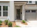 A close-up of a charming front entrance featuring a glass-paneled door, covered porch, and attached one-car garage at 1912 St John St, Charlotte, NC 28216