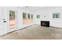 Bright living room featuring a fireplace, large windows, and neutral walls at 1912 St John St, Charlotte, NC 28216