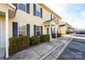 Row of townhouses with light yellow siding, dark shutters, and landscaping at 217 22Nd Sw St # H, Hickory, NC 28602