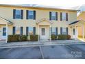 Two-unit townhouse building with light yellow siding, dark shutters, and covered entries at 217 22Nd Sw St # H, Hickory, NC 28602